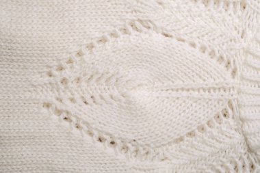 Beyaz örülmüş battaniyenin detaylı bir görüntüsü. Karmaşık desenler ve yakın dokular sergiliyor..