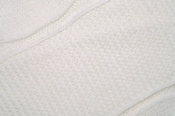 A detailed look at a white blanket, showcasing its texture and stitching. The fabric appears soft and smooth, with visible fibers.
