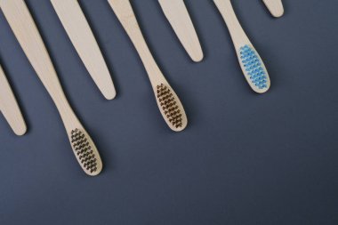 Pürüzsüz mavi bir yüzeyde beş diş fırçası düzenli bir şekilde sıralanır, görsel olarak memnun edici ve düzenli bir görüntü oluşturur..