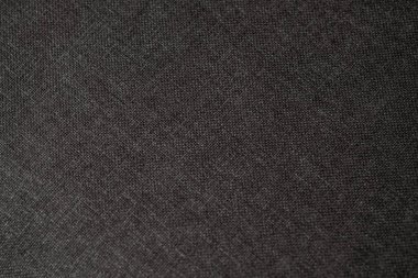 Koyu bir kumaşın yakın plan görüntüsü karmaşık dokusunu ve detaylı dokumasını ortaya çıkarır..