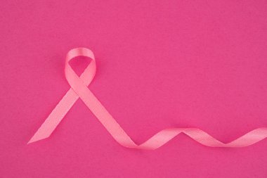 Pembe kurdele, göğüs kanseri dayanışmasını temsil eden açık pembe bir zemin üzerine kurulmuş..
