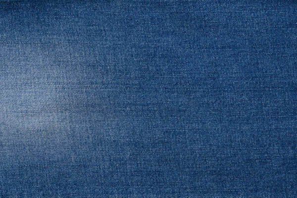 This close-up displays the texture and deep blue color of denim fabric fibers.