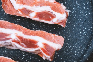 Domuz göbeği dilimleri siyah benekli bir tabakta düzgünce düzenlenir, bilyelerini sergilerler..