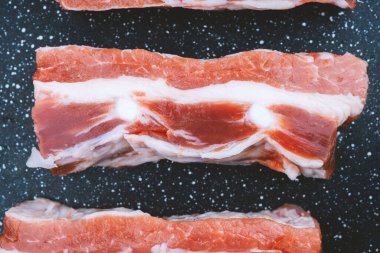 Domuz göbeği, siyah bir yüzeye düzgün bir şekilde yerleştirilmiş, mermer ve dokularını sergiliyor..