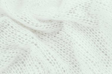 A delicate white knitted fabric drapes softly, highlighting its intricate weave and texture. clipart