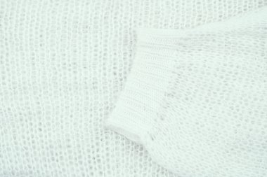 Close-up view of soft white knit fabric showcasing its texture and weave pattern. clipart