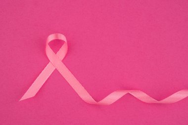Pembe kurdele, göğüs kanseri dayanışmasını temsil eden açık pembe bir zemin üzerine kurulmuş..