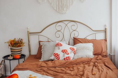 Zarif bir yatak odası. Toprak renkler ve dekoratif unsurlar var. Rahatlamaya davetiye çıkarıyor..