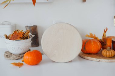 Samimi bir mutfak tezgahında sonbahar dekorunda balkabakları ve canlı yapraklar sergilenir..