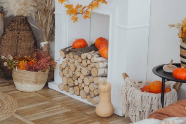 Mevsimlik cazibe için balkabakları, yakacak odunları ve sonbahar süslemeleri olan sıcak bir yaşam alanı..