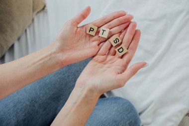 Bir kişi, PTSD 'yi heceleyen ve zihinsel sağlık sorunlarıyla ilgili farkındalığı artıran harf taşları sergiliyor.