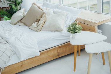 Rahat bir yatak odasında yumuşak yastıklar ve yumuşak çarşaflarla süslenmiş ahşap bir yatak vardır..