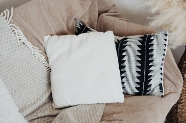 Rahat bir ortamda, dekoratif iki yastığın yanındaki sandalyenin üzerine yumuşak battaniye örtüleri atın..