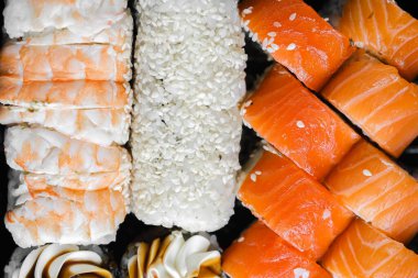 Karides, somon ve pirinç rulolarını da içeren canlı bir suşi çeşidi..