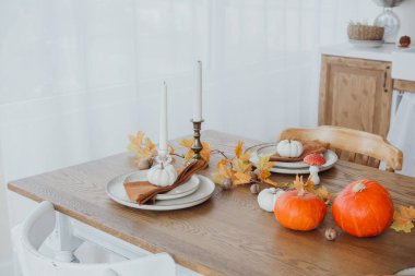 Sıcak yemek düzenlemelerinde balkabakları, mumlar ve sonbahar yaprakları mevsimlik kutlama için sergilenir..