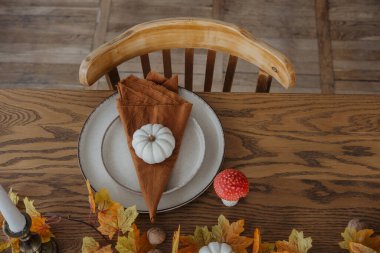 Bir balkabağı, peçete ve mevsimlik yemek için sonbahar süslemeleri içeren şenlik masası..