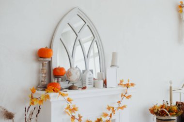 Süslü şömine raflarında balkabakları ve sonbahar yaprakları var. Sıcak ve davetkar bir atmosfer yaratıyorlar..