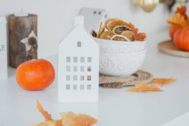 Beyaz Saray heykelciği, bir kase kurutulmuş meyve ve mevsimlik dekorasyonun yanında duruyor..