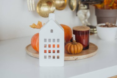 Samimi bir mutfak tezgahında balkabağı ve fener sergilenir, davetkar bir sonbahar atmosferi yaratır..