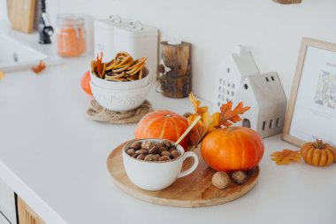 Balkabağı ve sonbahar yapraklarıyla süslenmiş sıcak bir mutfak neşeli bir atmosfer yaratır..