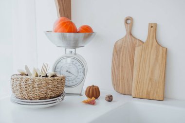 Taze meyveler ve dekoratif balkabakları mutfak tezgahında çatal bıçaklarla düzenlenir..