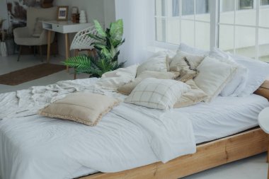 Sakin bir yatak odasında yumuşak yastıklar ve hafif yatak örtüleriyle süslenmiş büyük bir yatak vardır. Doğal ışık pencerelerden içeri akar ve uzayın sakin atmosferini arttırır..