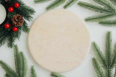 Merkeze doğal bir ahşap disk yerleştirilir, her zaman yeşil olan dallar ve çam kozalaklarıyla çevrili, tatil dekorasyonları veya el işi projeleri için ideal bir köy ve rahat bir atmosfer yaratır..