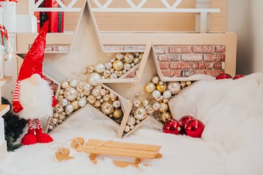 Colorful holiday decorations fill a warm space featuring two large stars filled with shiny ornaments. A festive gnome stands nearby, creating a joyful atmosphere for the season. clipart