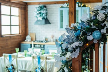 A cozy dining area adorned with blue and white decorations, including flowers and ornaments, sets the stage for a winter gathering. clipart