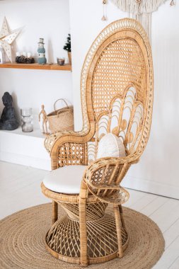 The elegant rattan chair showcases a unique design, adding a touch of warmth to the modern living room. Soft cushions enhance comfort against the minimalist decor background. clipart