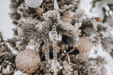 Güzel dekore edilmiş bir Noel ağacı, kış tatili için mükemmel bir şenlik atmosferi yaratan ışıl ışıl süslere ve donmuş dallara sahiptir..