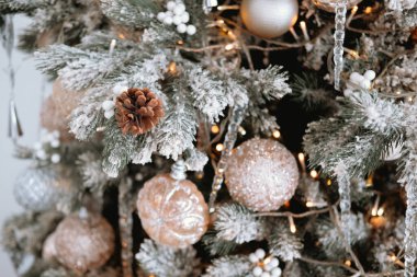 Noel ağacı buzlu dallarla süslenir, altın parıltılı süsler ve festival ışıklarıyla. Kutlama için mükemmel sıcak bir tatil atmosferi yaratır..