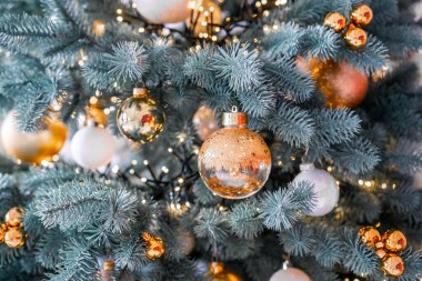 Çok güzel dekore edilmiş bir Noel ağacı, altın ve beyaz takılar da dahil olmak üzere parıldayan süsler sergiliyor ve bayram sezonu için mükemmel bir şenlik ortamı yaratıyor..