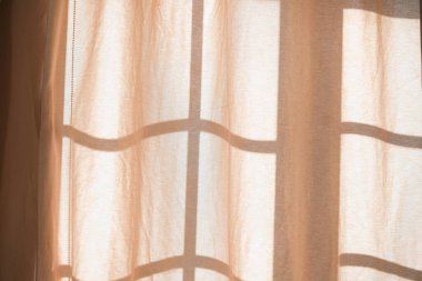 Yumuşak güneş ışığı perdelerin arasından akar, duvarlara hassas gölgeler bırakır ve davetkar iç mekanlara sıcaklık katar. Rahatlama ve sükunet için mükemmel bir ortam..