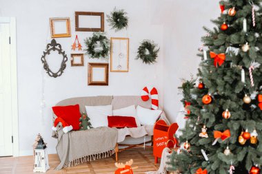 Oturma odası Noel için güzel dekore edilmiş bir ağaç, renkli süsler ve duvarlarda şenlikli süslemeler ile süslenmiş. Sıcak bir kanepe tatil sezonunda dinlenmeye davet eder..