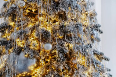 Göz kamaştırıcı bir Noel ağacı pırıl pırıl süsler ve ılık ışıklarla süslenir. Hoş bir kış ortamında renkli hediye kutularıyla çevrili neşeli bir atmosfer yaratır..