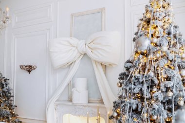 Güzel dekore edilmiş bir oda festival sezonunu kutlar. Işıklarla süslenmiş karlı bir Noel ağacı büyük bir hediye kutusunun yanında duruyor..