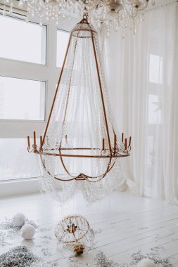 Tavandan sarkan narin kumaşlara sarılı çarpıcı bir avize, sıcak bir kış atmosferini güçlendiriyor..