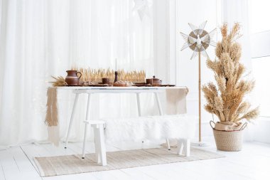 Çok güzel düzenlenmiş bir kış masasında, kurumuş bitkiler, çömlekçilik ve sıcak, davetkar bir ortam da dahil olmak üzere şenlik süsleri sergileniyor. Tatil toplantıları ve kutlamalar için mükemmel..