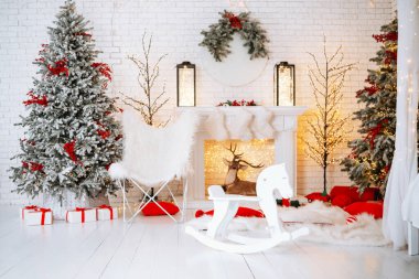 Bir festival odası iki karla kaplı Noel ağacı ve sıcak ışıklarla süslenerek ağaçların altında güzelce düzenlenmiş hediyeler sunuluyor. Beyaz bir sallanan at kış dekoruna eğlenceli bir dokunuş ekler..