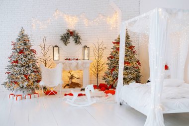 Güzel dekore edilmiş bir yerde kırmızı aksanlı iki Noel ağacı, rahat bir şömine ve beyaz bir yatak bulunur. Sahne, kış ve yeni yıl kutlamalarının şenlikli ruhunu yakalıyor..