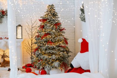 Sıcak bir kış ortamında süslerle ve ışıklarla süslenmiş neşeli bir Noel ağacı sergilenir. Yakınlarda, neşeli bir Noel Baba Noel ruhunu artırarak kutlamalar için sıcak bir ortam yaratıyor..