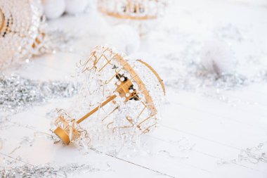 Renkli Noel süsleri parlak bir yüzeye saçılmış parlak süsler ve yumuşak kar taneleri ile çevrelenmiş. Bu neşeli gösteri bayram ve kış şenliklerini kutluyor..