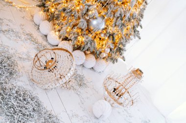 Güzel dekore edilmiş bir Noel ağacı altın ışıklarla süslenmiş ve hoş bir kış ortamında duruyor..