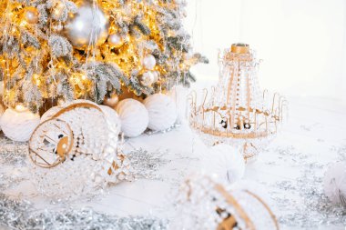 A beautifully decorated Christmas tree glows with warm lights and golden ornaments. Underneath, elegant gift boxes are arranged, adding a joyful touch to the winter ambiance. clipart