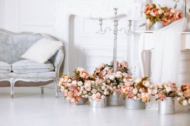 Büyüleyici bir odada, sıcak atmosferi geliştirmek için gümüş kaplarda güzel düzenlenmiş kış çiçekleri bulunur. Pofuduk koltuklar rahatlık katıyor, tatil için mükemmel bir yer yaratıyor..