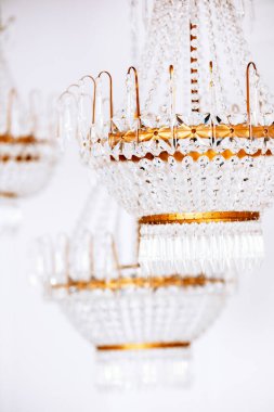 Tavandan zarif bir şekilde sarkan üç karmaşık kristal avize, sıcak ışık saçıyor. Noel ve yeni yıl şenliklerini kutlamak için mükemmel bir ortam oluşturuyorlar..