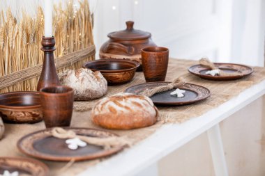 Çok güzel düzenlenmiş bir kış masasında rustik ahşap kaseler ve fincanlar bulunur. Ekmek ve eşsiz bir dekor eşliğinde. Bu şenlik ortamı Noel ve yeni yılın sıcaklığını kutluyor..