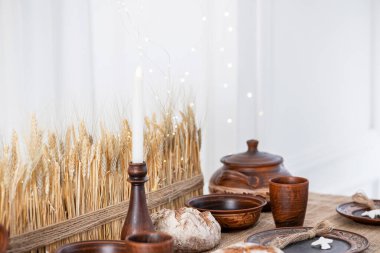 Noel ve Yeni Yıl kutlamaları için bir festival masası güzelce düzenlenmiştir, köy yemekleri, yanan bir mum ve dekoratif elementlerle birlikte..