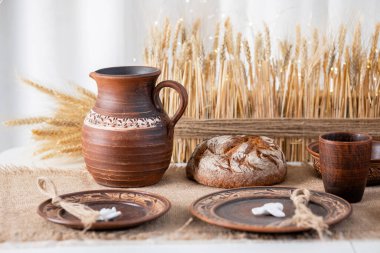 Geleneksel olarak el yapımı çömlek ve taze ekmek güzelce düzenlenerek, Noel kutlamaları için mükemmel sıcak bir kış ortamı yaratılıyor. Doğal elementler tatil ruhunu güçlendirir..